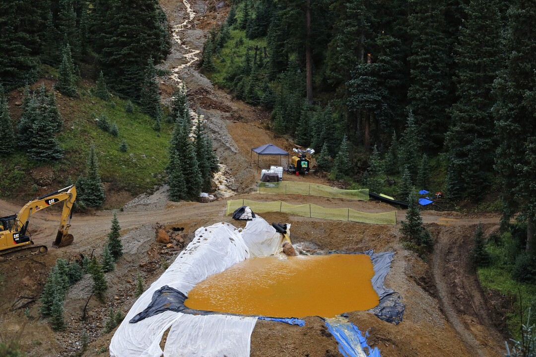 Water flows through one in a series of retention ponds built to contain and filter out heavy metals and chemicals from the Gold King mine wastewater accident, in the spillway about 1/4 mile downstream from the mine, outside Silverton, Colo., Wednesday, Aug. 12, 2015. The Environmental Protection Agency has taken full responsibility for the mine waste spoiling rivers downstream from Silverton, but people who live near the idled and leaking Gold King mine say local authorities and mining companies spent decades spurning federal cleanup help. (AP Photo/Brennan Linsley)