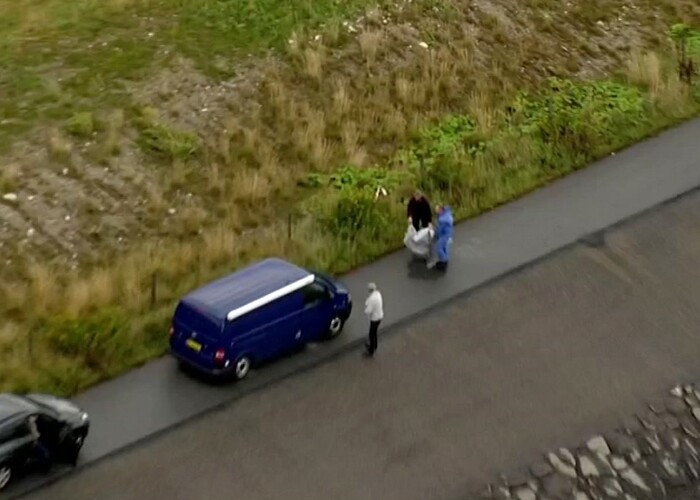 In this image taken from video on Monday Aug. 21, 2017, shows police forensic investigators moving a  headless body of a woman that was found near Amager Denmark in the Baltic Sea  where a missing Swedish journalist is believed to have died on a privately built submarine earlier this month.  The headless torso found on a beach near Amager has been identified as that of missing Swedish journalist Kim Wall, Danish police said Wednesday Aug. 23, 2017. (TV2 via AP)