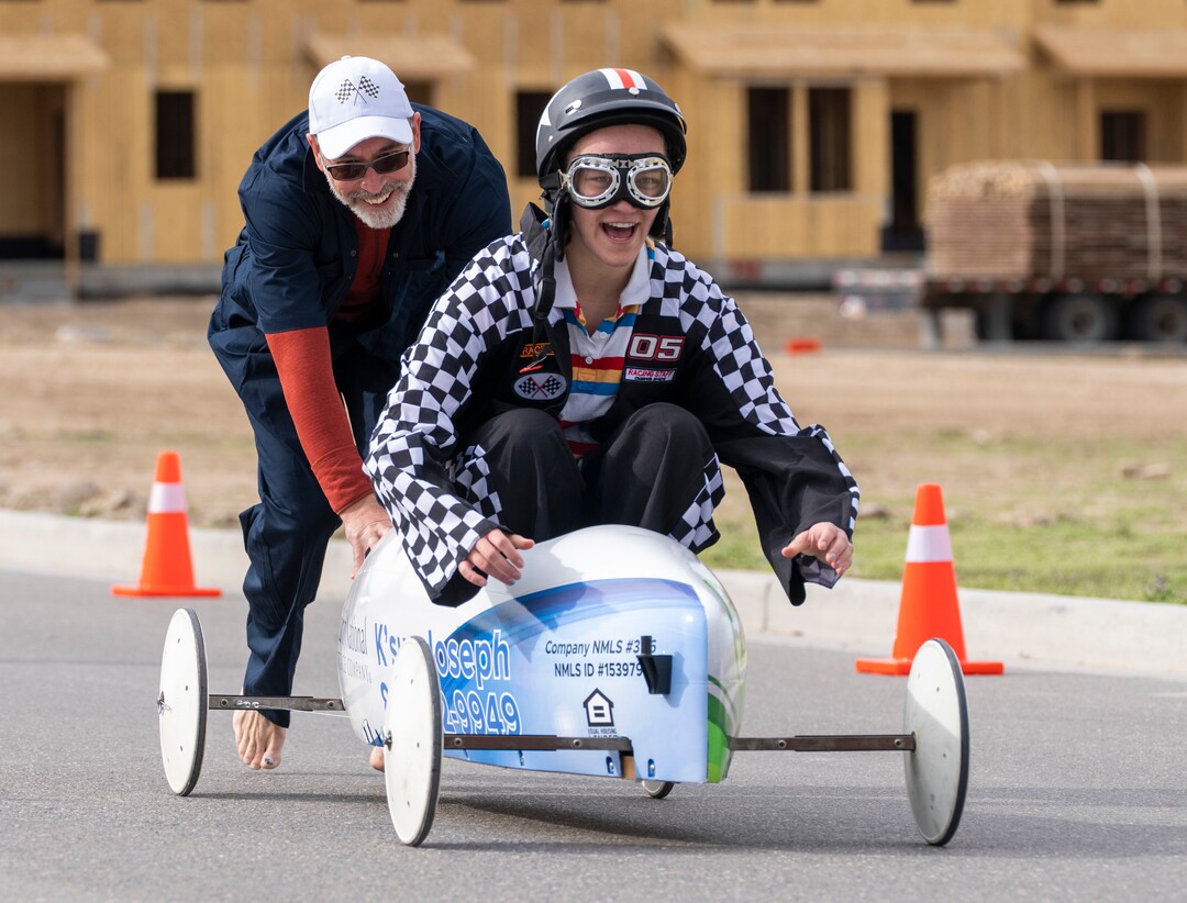 (Rick Egan | The Salt Lake Tribune) Chris Merrill pushes Bethay Merrill, during a contest, at the Daybreak Soap Box Derby, on Saturday, April 24, 2021.