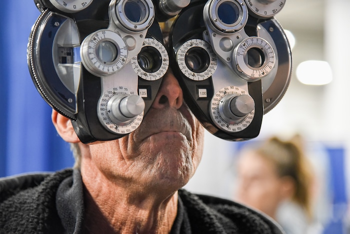 (Francisco Kjolseth  |  The Salt Lake Tribune)  Mark Aucoin looks through a Phoropter as he gets outfitted for glasses during Salt Lake CityÕs second annual Project Homeless Connect takes place at the Salt Palace Convention Center on Friday, Oct. 12, 2018. More than 800 community volunteers and 90 service providers connect those in need with more than 200 services.
