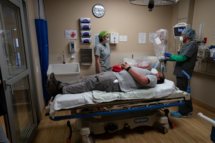 Team Rubicon volunteer, EMT Hannah Tellier from Boston, left, and a member of the Kayenta Health Center staff prepare to practice with a new shield that just arrived to help protect medical workers when they intubate patients, in Kayenta, Ariz., on the Navajo Reservation on April 23, 2020. Assisting the medial staff on the table, posing as a patient, is Team Rubicon safety officer and EMT Vick Dempsey. (AP Photo/Carolyn Kaster)