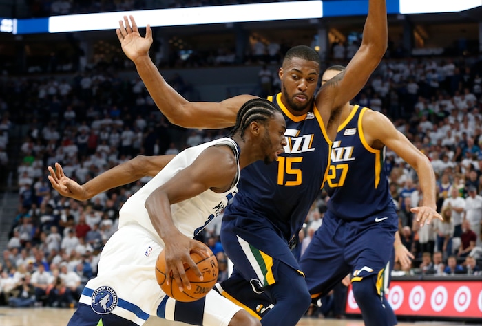 Minnesota Timberwolves' Andrew Wiggins, left, drives around Utah Jazz's Derrick Favors during the fourth quarter of an NBA basketball game Friday, Oct. 20, 2017, in Minneapolis. The Timberwolves won 100-97. (AP Photo/Jim Mone)