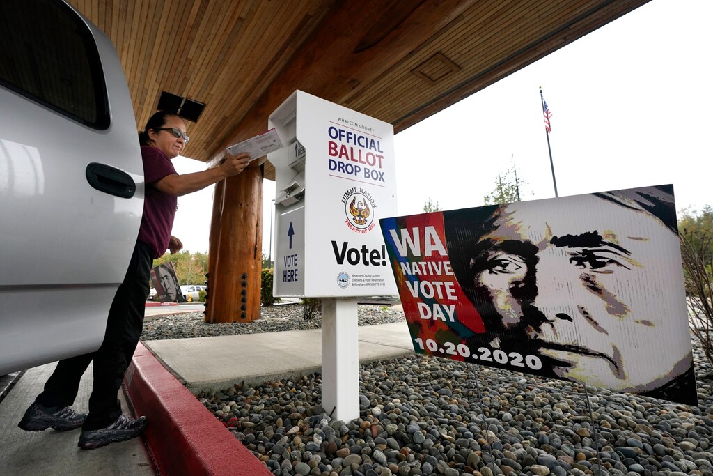 (Elaine Thompson | AP file photo) In October, Lummi Nation tribal member Karen Scott drops her completed ballot into a ballot drop box on the Lummi Reservation, near Bellingham, Wash. Data from The Associated Press' AP VoteCast, a nationwide survey of more than 133,000 voters and non-voters, showed 52% of Native Americans supported Donald Trump while 45% favored Joe Biden — a statistic that was largely discounted in Indian Country because Native Americans long have been considered the Democratic Party's constituency.