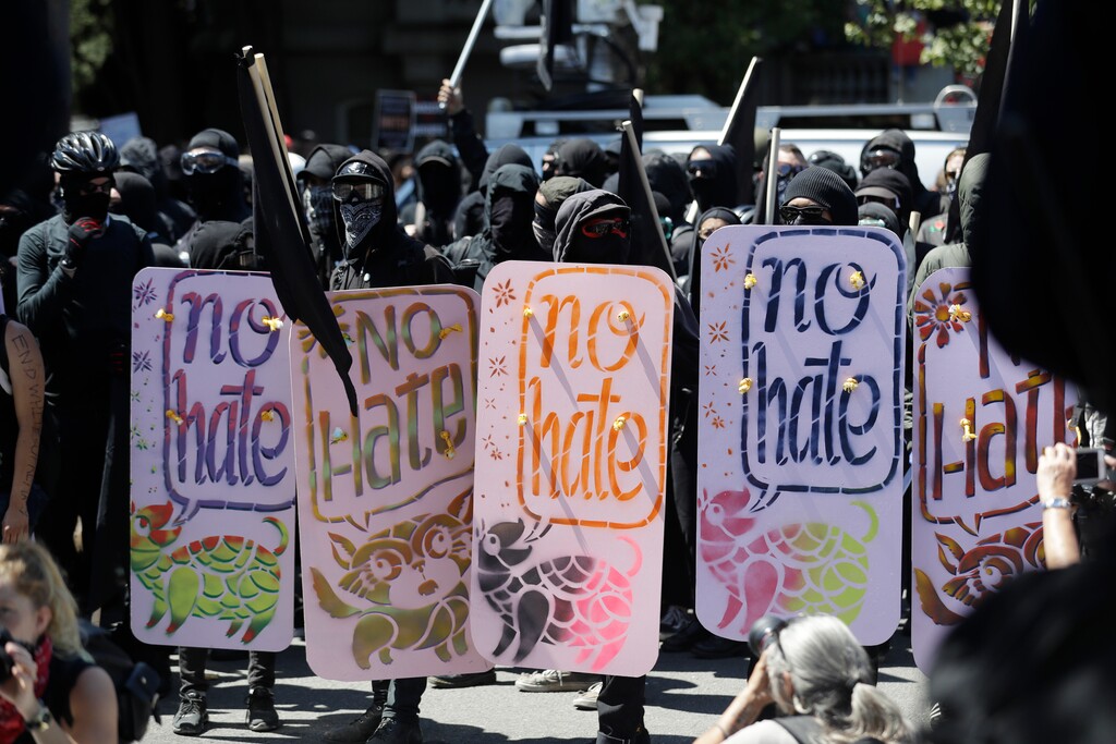 Demonstrators hold shields during a free speech rally Sunday, Aug. 27, 2017, in Berkeley, Calif. Several thousand people converged in Berkeley Sunday for a "Rally Against Hate" in response to a planned right-wing protest that raised concerns of violence and triggered a massive police presence. Several people were arrested for violating rules against covering their faces or carrying items banned by authorities. (AP Photo/Marcio Jose Sanchez)