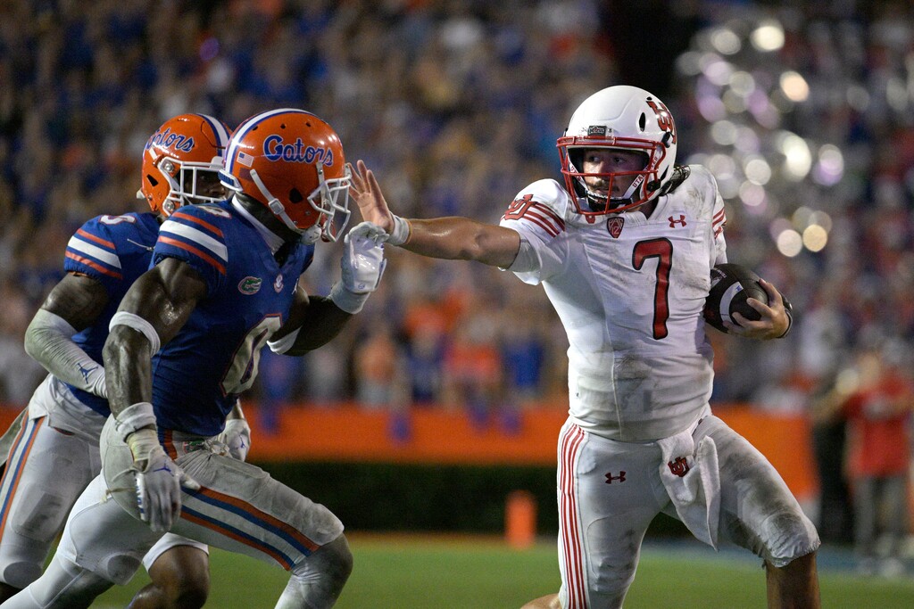 (Phelan M. Ebenhack | AP) Utah quarterback Cameron Rising (7) stiff arms Florida safety Trey Dean III (0) while scrambling for yardage during the second half of an NCAA college football game, Saturday, Sept. 3, 2022, in Gainesville, Fla.