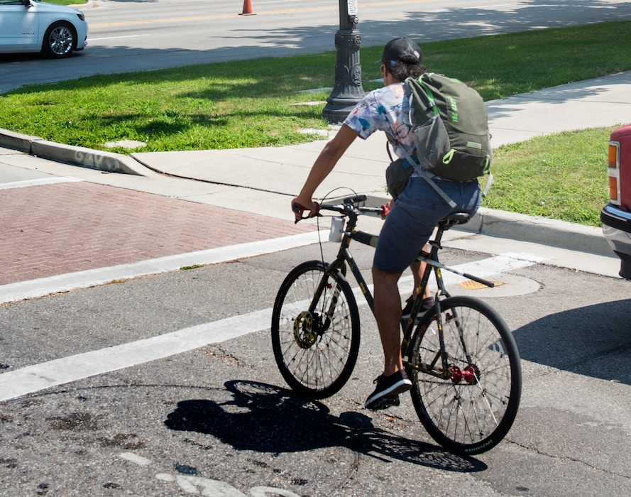 (Rick Egan  | Tribune file photo) A bicyclist rides in downtown Salt Lake City on Aug. 1, 2018. A House committee advanced a bill Wednesday that would allow bicyclists to treat stop signs like yield signs.