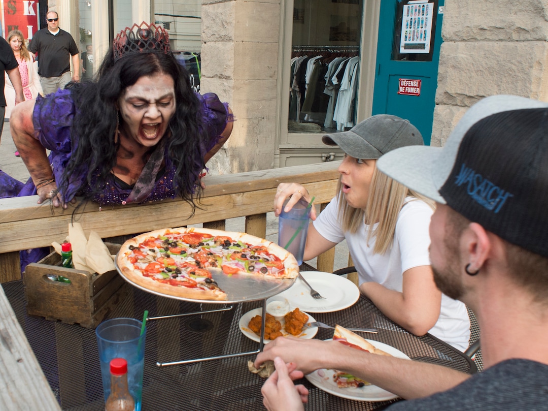 (Rick Egan  |  The Salt Lake Tribune)       Marlana Mompus Bryan scares a couple dining on 200 South, during the 11th annual Zombie Walk, Sunday, Aug. 26, 2018.