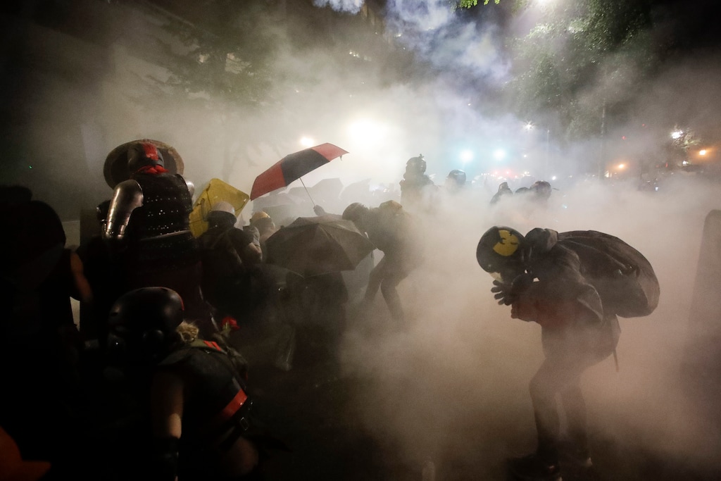 (Marcio Jose Sanchez | The Associated Press) Federal officers launch tear gas at a group of demonstrators during a Black Lives Matter protest at the Mark O. Hatfield United States Courthouse Sunday, July 26, 2020, in Portland, Ore.