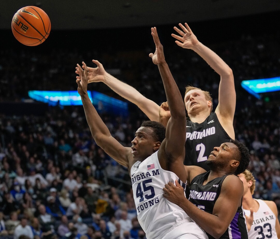 (Francisco Kjolseth | The Salt Lake Tribune) Brigham Young Cougars forward Fousseyni Traore (45) battles for a rebound against Portland Pilots guard Tyler Robertson (2) and Portland Pilots guard Chika Nduka (15) in WCC basketball action between the Brigham Young Cougars and the Portland Pilots, at the Marriott Center, on Saturday, January 22, 2022.