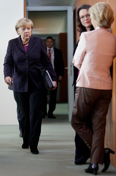 German Chancellor Angela Merkel, left, looks at German Defence Minister Ursula von der Leyen, right, and German Labor Minister Andrea Nahles, second right, as she arrives for the weekly cabinet meeting at the chancellery in Berlin, Germany, Wednesday, Nov. 5, 2014. (AP Photo/Michael Sohn)
