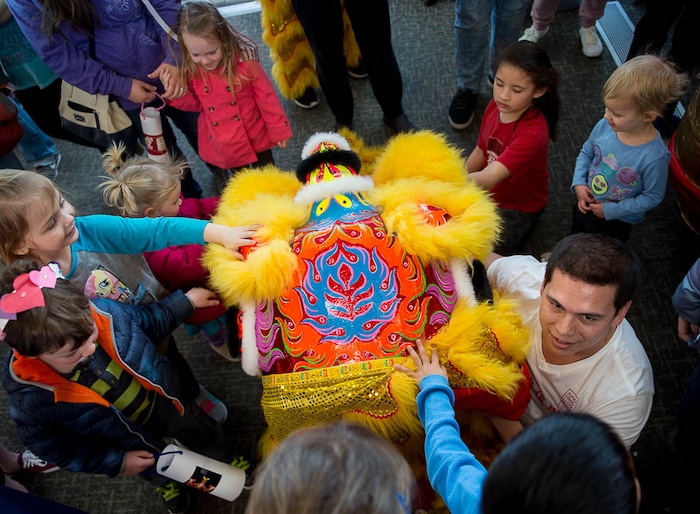 (Trent Nelson | The Salt Lake Tribune)  Children swarm around Itzak Lefler and his lion head following a performance by Jung Hing Dragon Dance at the Chinese New Year Celebration at the County Library's Viridian Event Center in West Jordan, Saturday Feb. 17, 2018.