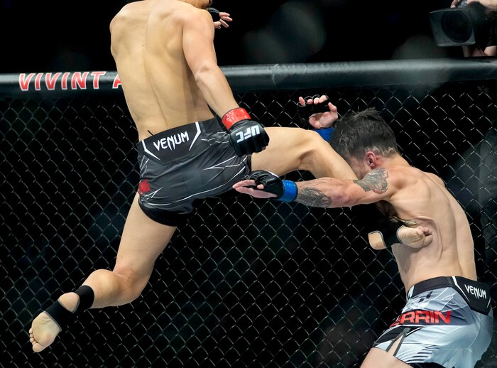 (Francisco Kjolseth | The Salt Lake Tribune) Aoriqileng of China lands a flying kick into Jay Perrin of the United States during their bantamweight bout at Vivint Arena for UFC 278 on Saturday, Aug. 20, 2022. 