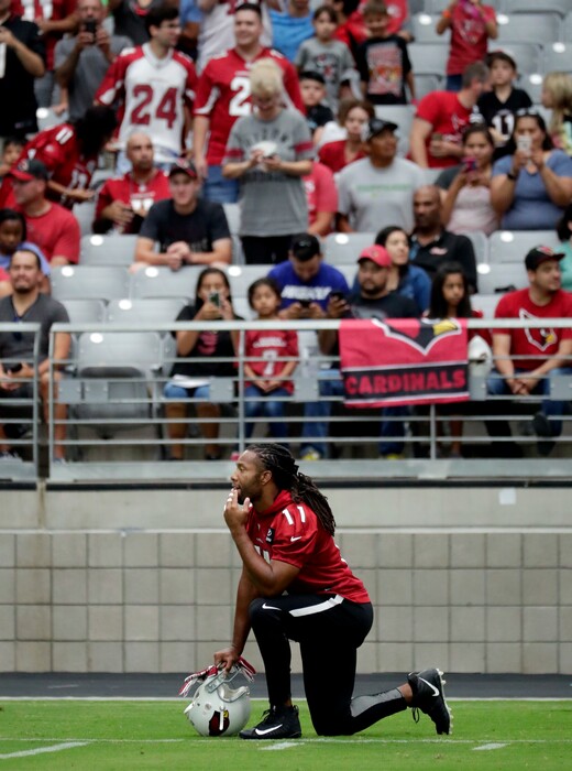 Arizona Cardinals wide receiver Larry Fitzgerald takes a knee during the first day of the team's NFL football training camp, Saturday, July 22, 2017, in Glendale, Ariz. (AP Photo/Matt York)
