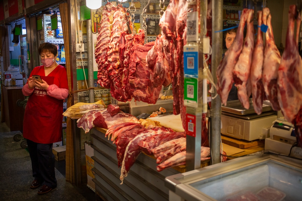 (Mark Schiefelbein | AP file photo)  An employee wears a face mask as she waits for customers at a meat stall at a market in Beijing, Saturday, March 14, 2020.