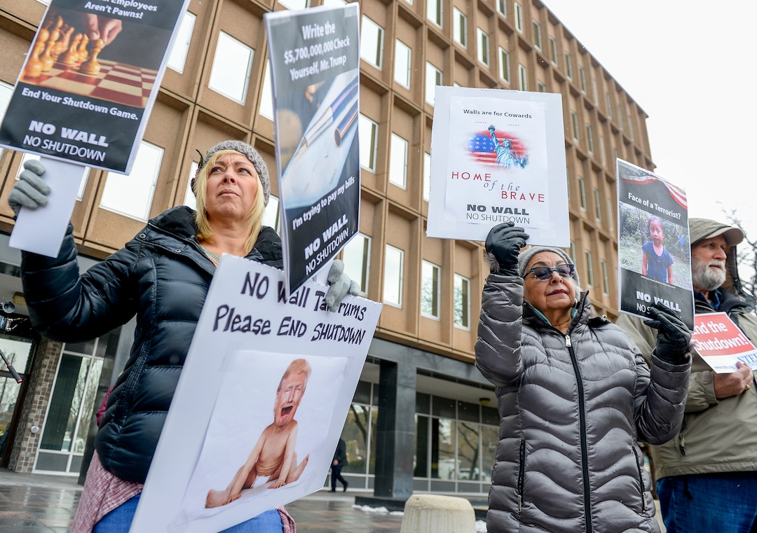 Leah Hogsten  |  The Salt Lake Tribune  l-r Dawn Malan and her mother Maria Anita Gutierez Cope and John Bellmon rally with Internal Revenue Service employees in protest of the ongoing partial federal shutdown outside the Federal Building in Ogden, Jan. 10, 2019.