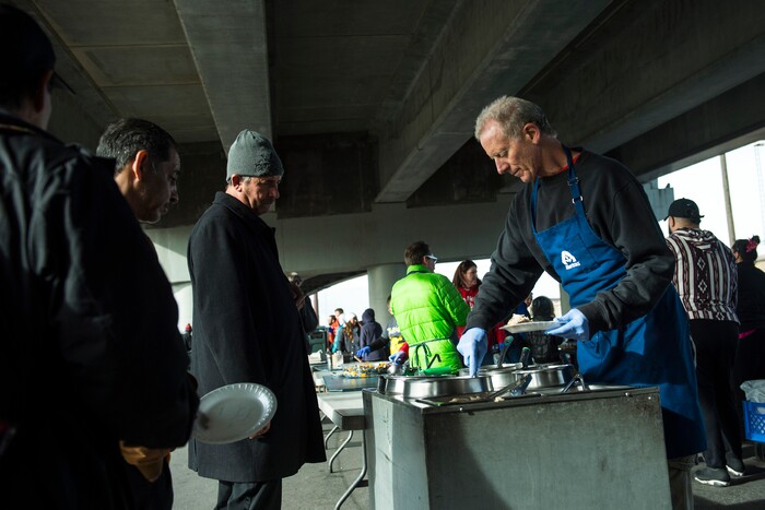 (Chris Detrick | The Salt Lake Tribune) Volunteer Brent Levetan serves Thanksgiving Day meals during the Eagle Ranch Chuckwagon under the viaduct at 500 South and 600 West in Salt Lake City Thursday, November 23, 2017.