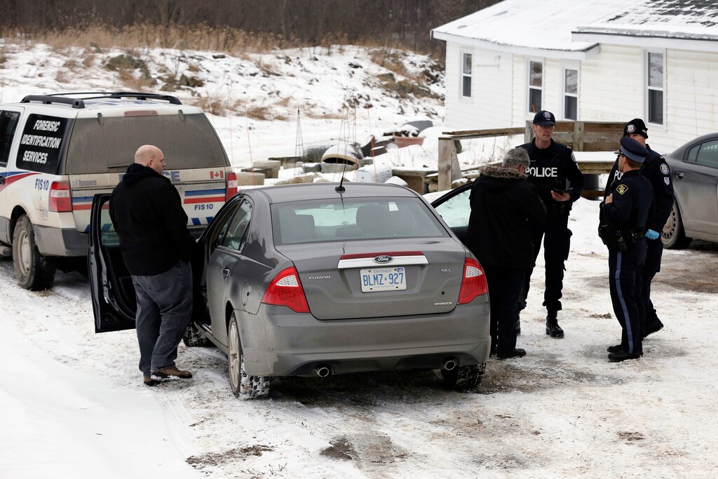FILE - In this Jan. 19, 2018 file photo, forensic officers stand outside a house connected to Bruce McArthur, an alleged serial killer, in Madoc, Ontario. Toronto police say said Monday, Jan. 29, 2018, that McArthur, a 66-year-old Toronto landscaper, has been charged with three more counts of first degree murder, bringing the total to five. (Lars Hagberg/The Canadian Press via AP File)