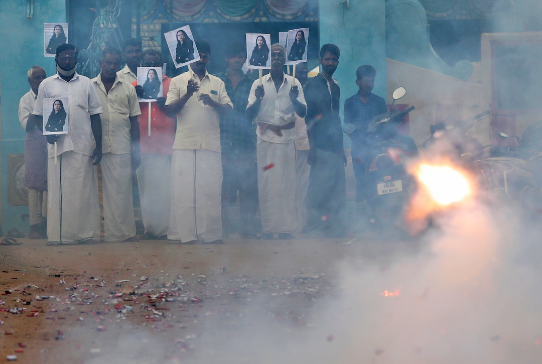 Villagers burst firecrackers and hold placards featuring U.S. Vice President-elect Kamala Harris ahead of her inauguration, in Thulasendrapuram, the hometown of Harris' maternal grandfather, south of Chennai, Tamil Nadu state, India, Wednesday, Jan. 20, 2021. A tiny, lush-green Indian village surrounded by rice paddy fields was beaming with joy Wednesday hours before its descendant, Kamala Harris, takes her oath of office and becomes the U.S. vice president. (AP Photo/Aijaz Rahi)