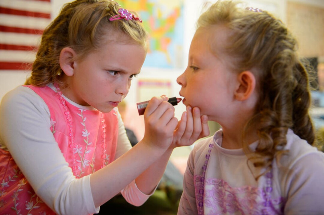 (Trent Nelson | The Salt Lake Tribune)  A princess party was thrown for several young FLDS girls in Colorado City, Ariz., Friday March 16, 2018, as a reward for reading books. Before the party, Kathy Bistline puts lipstick on her sister Lolly during their first experience with makeup.