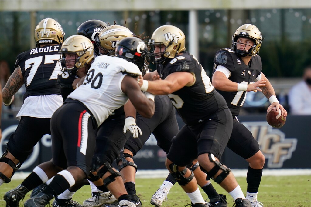 Central Florida quarterback Dillon Gabriel, far right, throws a pass against Cincinnati during the first half of an NCAA college football game, Saturday, Nov. 21, 2020, in Orlando, Fla. (AP Photo/John Raoux)