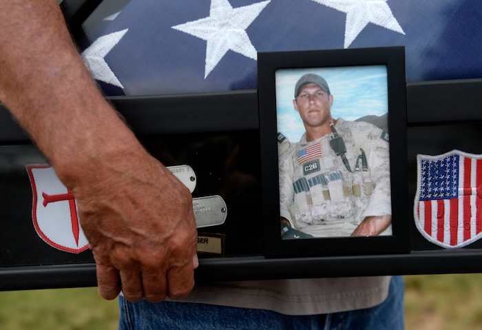 Al Hartmann  |  The Salt Lake Tribune 
Rodney Workman of Blanding holds a case of dog tags, Marine patches and the American flag that honored their son Jason who was buried with honors at Arlington Cemetery.  Jason Workman, a member of Seal Team 6 was among 38 military personnel shot down by Taliban fighters in a Chinook helicopter on Aug. 6, 2011. It was the largest loss of U.S. life in the Afghanistan campaign.  Two Utahns were on the helicopter,  Taylorsville's Jared Day and Blanding's Jason Workman. Five years later, family and friends still grapple with their absence while battling to keep alive their memory — Workman, as a big, daring family man with a kind heart and Day as a "goofball" who loved video games and anime and who could make people laugh during times of extreme stress.
The two men shared a birthday, Aug. 12.  