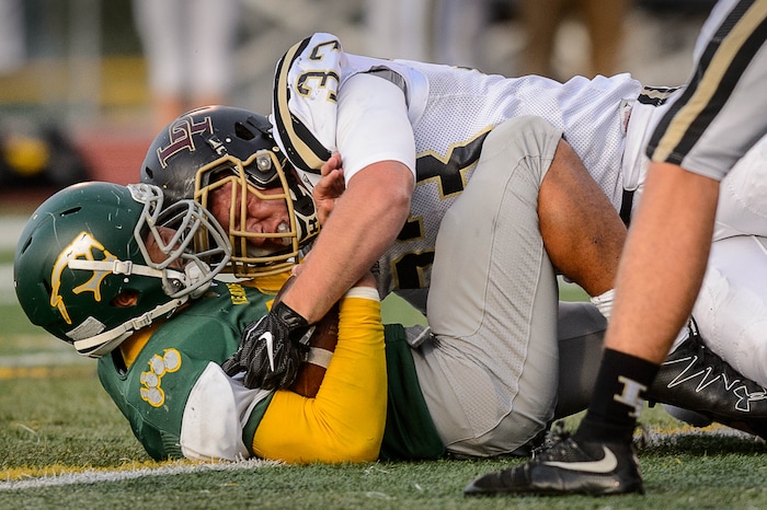 (Trent Nelson | The Salt Lake Tribune) Kearns' Sese Felila is brought down by Lone Peak's Brady Shimanek as Kearns hosts Lone Peak, high school football, Thursday September 14, 2017.