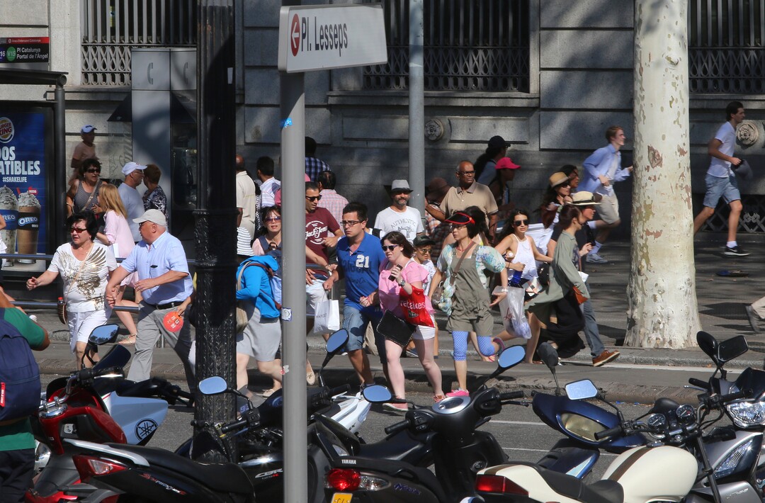 People flee the scene in Barcelona, Spain, Thursday, Aug. 17, 2017 after a white van jumped the sidewalk in the historic Las Ramblas district, crashing into a summer crowd of residents and tourists and injuring several people, police said. (AP Photo/Oriol Duran)