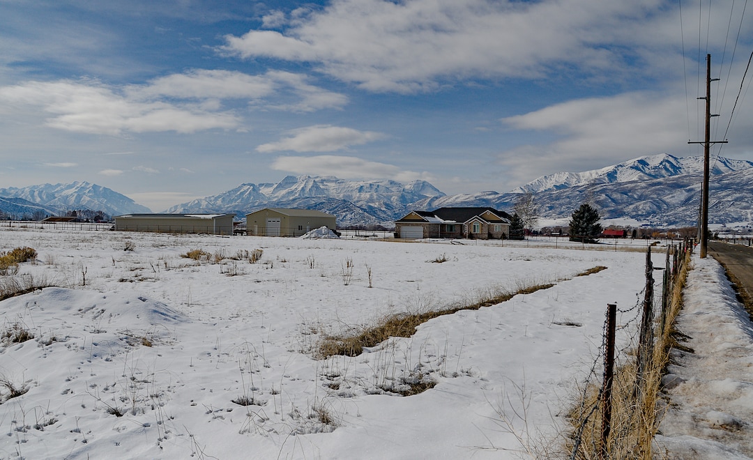 (Francisco Kjolseth  |  The Salt Lake Tribune)  A much larger power line will soon replace a current line, at right, along with a planned substation in the field at left in Midway. Residents, are trying to convince Rocky Mountain Power to bury one mile of the transmission line through the scenic Heber Valley town. They are even willing to covering the cost, but the utility is challenging the town's requirement that the new line go underground.