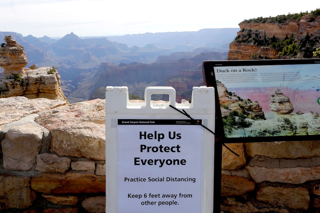 (Matt York | The Associated Press)
A social distancing sign is seen at the Grand Canyon Friday, May 15, 2020, in Grand Canyon, Ariz. Tourists are once again roaming portions of  Grand Canyon National Park when it partially reopened Friday morning, despite objections that the action could exacerbate the coronavirus pandemic.