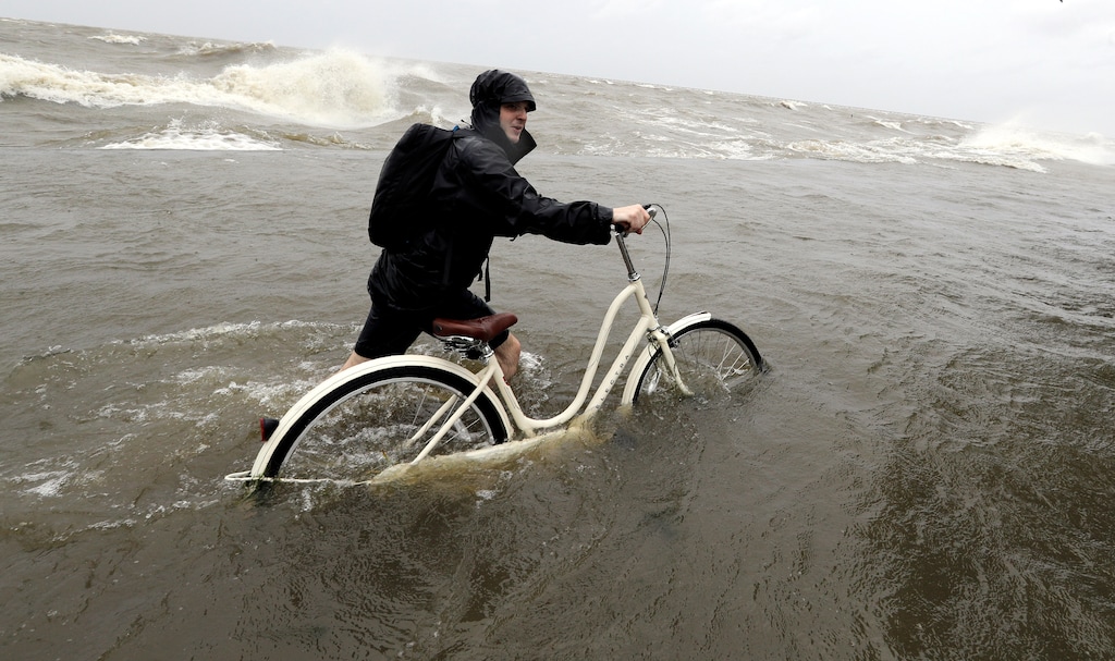 (David J. Phillip | The Associated Press)
Tyler Holland guides his bike through the water as winds from Tropical Storm Barry push water from Lake Pontchartrain over the seawall Saturday in Mandeville, La.