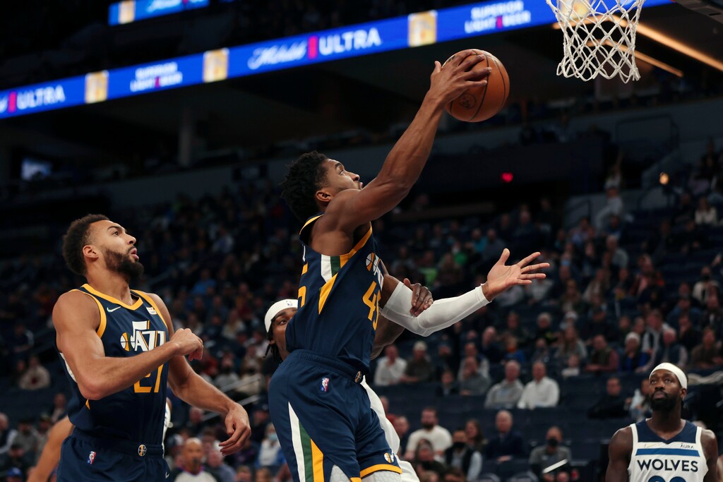 Utah Jazz guard Donovan Mitchell (45) is fouled by Minnesota Timberwolves forward Jarred Vanderbilt (8) during the first half of an NBA basketball game Wednesday Dec. 8, 2021, in Minneapolis. Utah won 136-104. (AP Photo/Stacy Bengs)