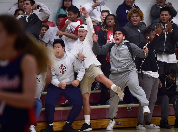 (Scott Sommerdorf   |  The Salt Lake Tribune)   Some members of the East football team cheered on the girl's basketball team as East beat Woods Cross 50-36, Friday, December 15, 2017.  