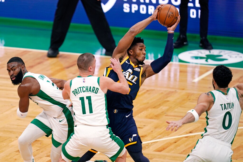 Utah Jazz guard Donovan Mitchell looks to pass the ball while guarded by Boston Celtics during the second half of an NBA basketball game, Tuesday, March 16, 2021, in Boston. From left are Celtics guard Jaylen Brown (7), guard Payton Pritchard (11) and forward Jayson Tatum (0). (AP Photo/Charles Krupa)