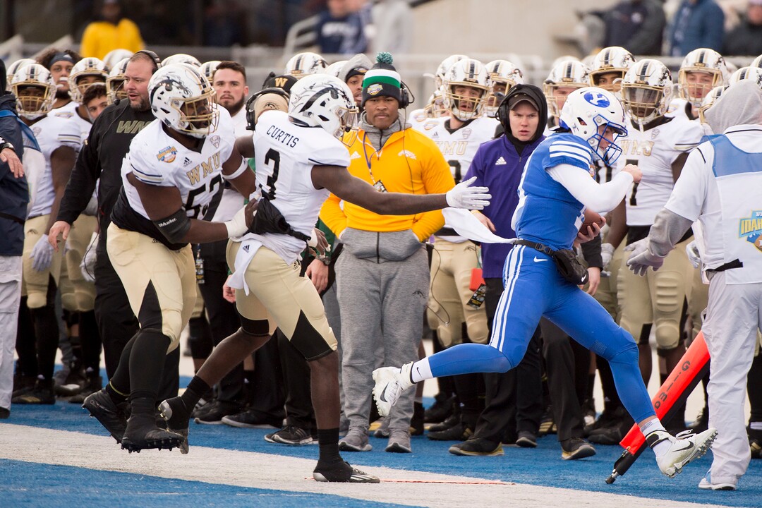 (Jeremy Harmon  |  The Salt Lake Tribune) Brigham Young Cougars quarterback Zach Wilson (11) is chased out of bounds by Western Michigan Broncos wide receiver Anton Curtis (3) as BYU faces the Western Michigan Broncos in the Famous Idaho Potato Bowl in Boise, Idaho, on Friday, Dec. 21, 2018.