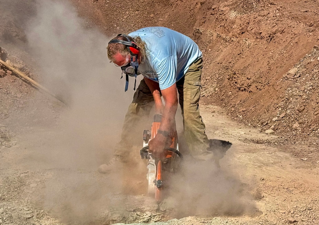 (Mark Eddington | The Salt Lake Tribune) Paleontologist Andrew Milner uses a concrete saw to loosen blocks at a St. George dinosaur site, Wednesday, March 26, 2025. Volunteers are racing to extract fossils at the site before construction begins on a power substation.