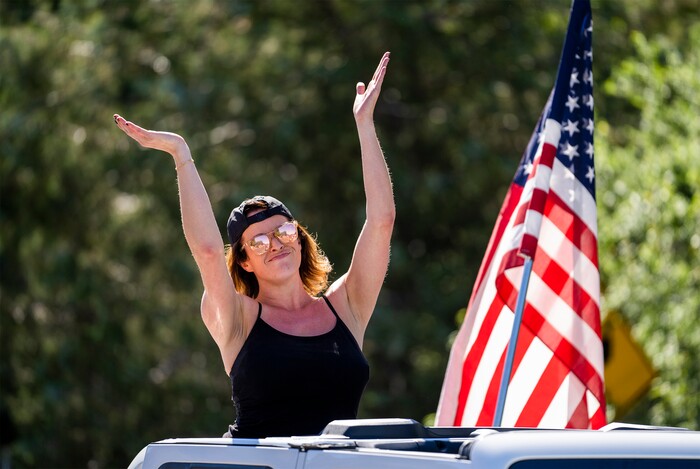 (Rick Egan | The Salt Lake Tribune)  A woman dances as she rides in the Jeep convoy in the Cherry Days Fourth of July celebration, in North Ogden, on Monday, July 4, 2022.
