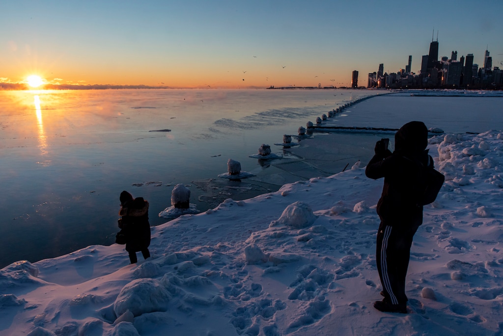 With temperatures below zero, photographers capture the sun rising over a frigid Lake Michigan and the Chicago skyline Sunday, Feb. 7, 2021. (Brian Cassella /Chicago Tribune via AP)