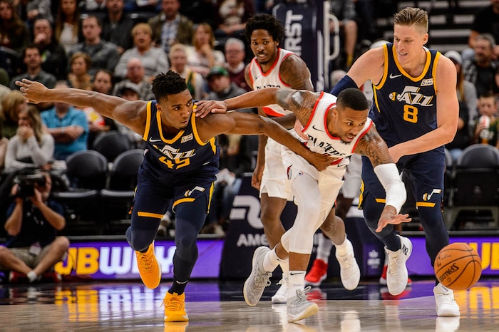 (Trent Nelson | The Salt Lake Tribune)  Portland Trail Blazers guard Damian Lillard (0) reaches out for a loose ball as the Utah Jazz host the Portland Trail Blazers, NBA basketball in Salt Lake City, Wednesday November 1, 2017. At left is Utah Jazz guard Donovan Mitchell (45) and right is Utah Jazz forward Jonas Jerebko (8).