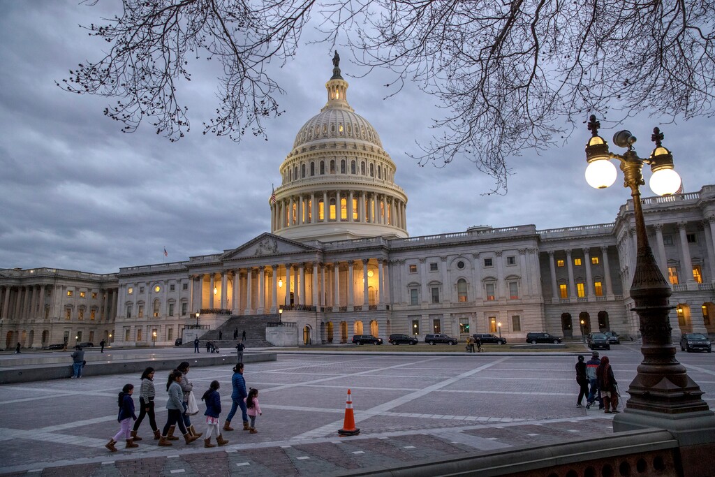 FILE - In this Jan. 21, 2018, file photo, people walk by the U.S. Capitol on the second day of the federal shutdown as lawmakers negotiate behind closed doors in Washington.  After last year’s big win on taxes, Republicans controlling Capitol Hill are opting for a scaled-back, controversy-free agenda. President Donald Trump’s trillion-dollar-plus plan to boost infrastructure has landed with a thud. Hopes in the House of taking on so-called welfare reform seem likely to fizzle in the Senate. Instead, the GOP-controlled Congress is looking ahead to a year of abbreviated work weeks and low-profile and small-bore initiatives. (AP Photo/J. Scott Applewhite)