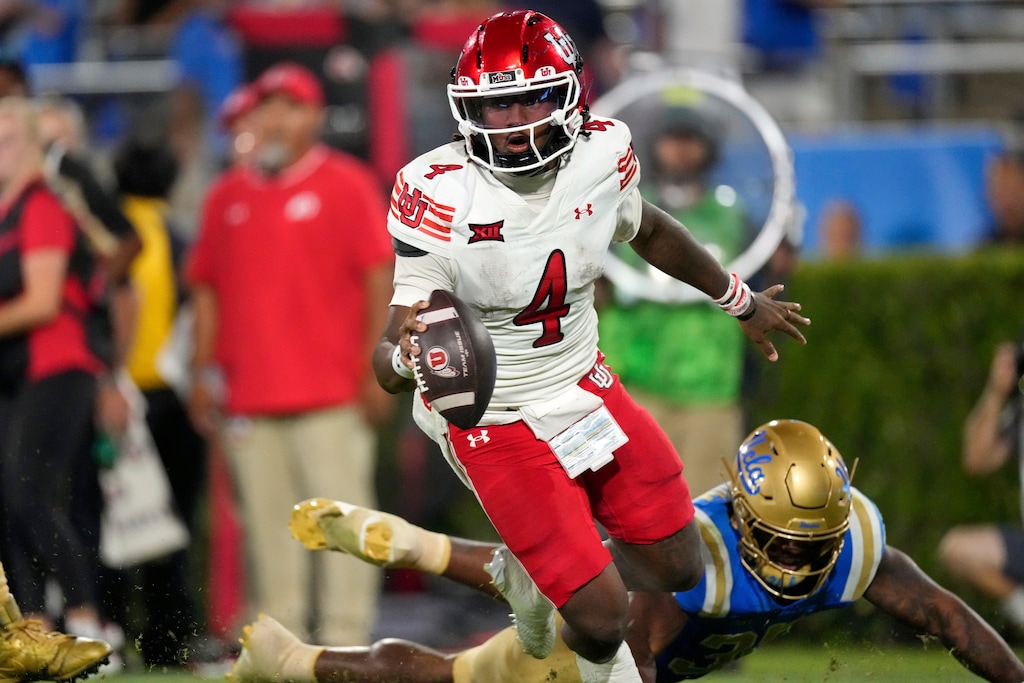 (Mark J. Terrill | AP) Utah quarterback Devon Dampier, top, rolls away after UCLA linebacker Isaiah Chisom missed a tackle during the second half of a college football game, Saturday, Aug. 30, 2025, in Pasadena, Calif.