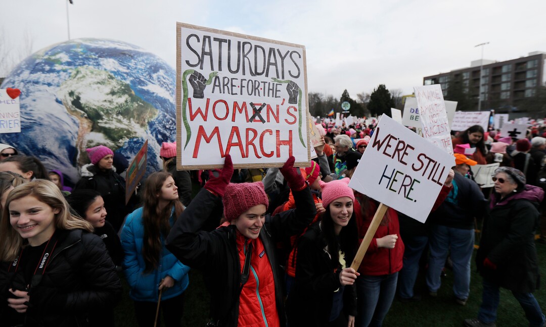 A woman holds as sign as she takes part in a Women's March in Seattle, Saturday, Jan. 20, 2018. The march was one of dozens planned across the U.S. over the weekend. (AP Photo/Ted S. Warren)