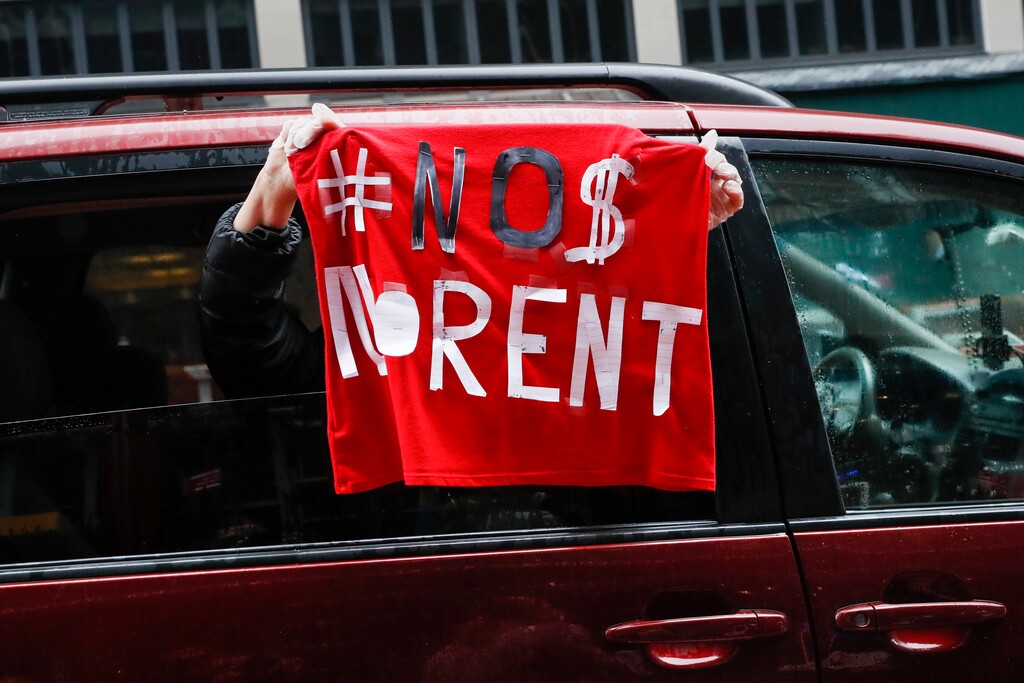 A sign with the message to cancel rent is displayed from a vehicle as a caravan of May Day protesters drives up 2nd Avenue outside the offices of New York Gov. Andrew Cuomo, Friday, May 1, 2020, in the Manhattan borough of New York. (AP Photo/John Minchillo)