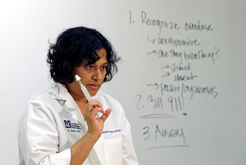 In this May 11, 2016, photo, University of Massachusetts Medical School instructor Kavita Babu holds up a syringe of nasal Naloxone for emergency treatment of opioid overdose, during a class about the biology of addiction at the medical school in Worcester, Mass. (AP Photo/Elise Amendola)