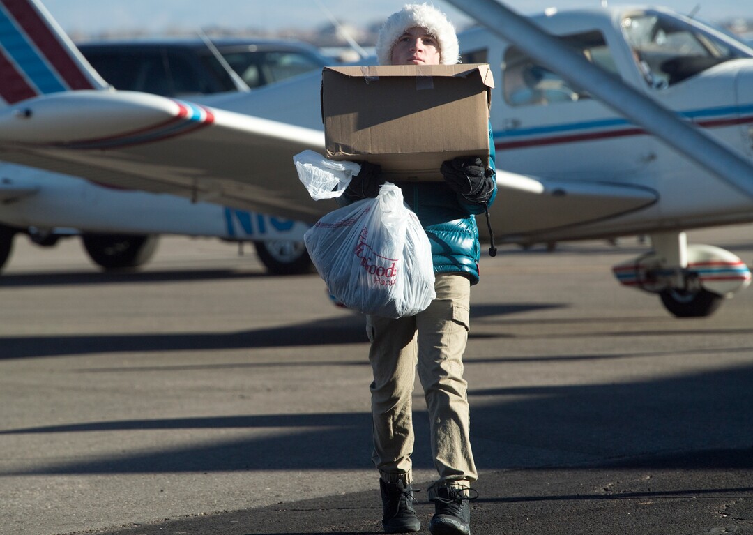 (Rick Egan  |  The Salt Lake Tribune) Luke Larsen, of Salt Lake City loads up some of the donations for Centennial Elementary School, in Roosevelt, Utah. Larsen helped gather items for the school as part of his eagle scout project. Volunteer pilots from the Utah Wing of Angel Flight West,  brought school supplies and gifts to students in Roosevelt on their annual Santa Flight. Friday, December 8, 2017.