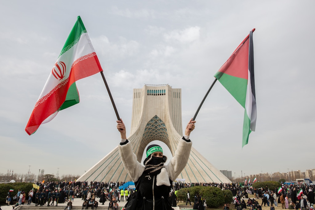 (Arash Khamooshi | The New York Times) The national flag of the Islamic Republic of Iran is waved as thousands gather near Azadi Tower to commemorate the 47th anniversary of the Islamic Revolution in Tehran, Iran, Feb. 11, 2026.