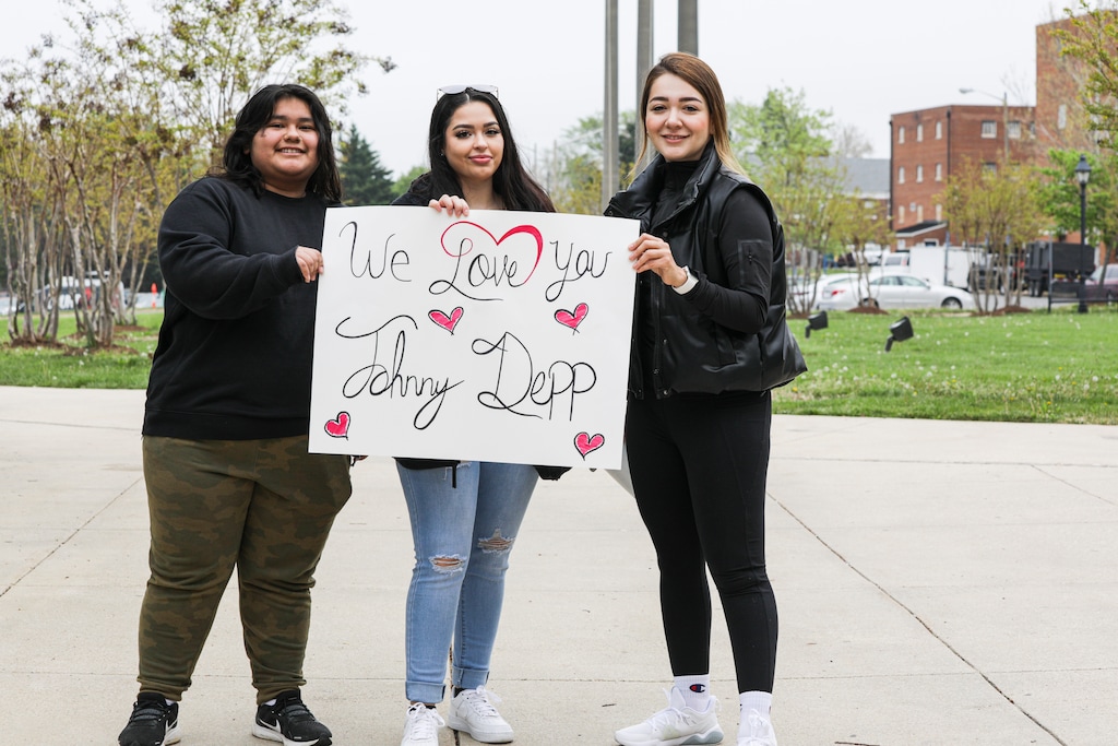 (Valerie Plesch | The New York Times)

From left, Ines Sorto-Rojas, Kailyn Diaz, and Anasofia Almanac show their support for actor Johnny Depp outside the courthouse in Fairfax, Virginia, April 25, 2022. A frenzied scene materializes four days a week at the Fairfax County Courthouse as fans seek seats at the defamation trial between Depp and Amber Heard, his ex-wife.