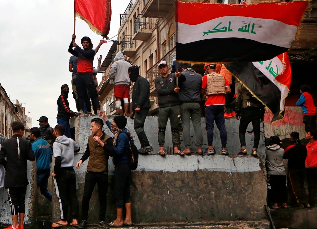 (Khalid Mohammed | AP) Anti-government protesters gather on barriers set up by security forces to close Rasheed Street during ongoing protests in Baghdad, Iraq, Tuesday, Dec. 3, 2019. At least 400 people have died since the leaderless uprising shook Iraq on Oct. 1, with thousands of Iraqis taking to the streets in Baghdad and the predominantly Shiite southern Iraq decrying corruption, poor services, lack of jobs and calling for an end to the political system that was imposed after the 2003 U.S. invasion.
