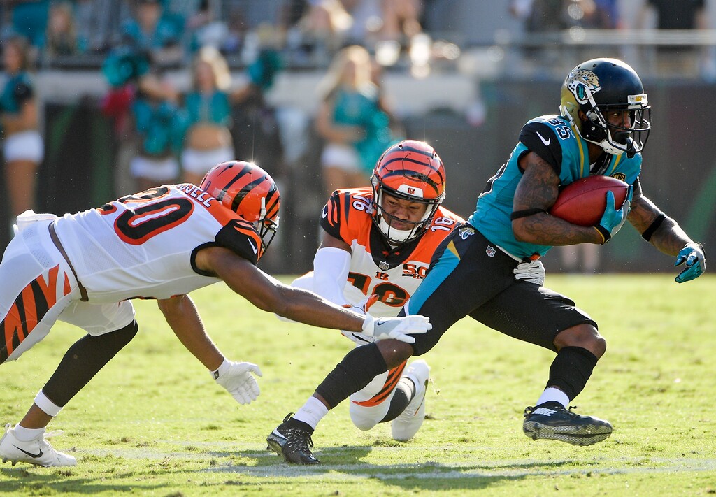 Jacksonville Jaguars' Jaydon Mickens, right, slips past Cincinnati Bengals cornerback KeiVarae Russell (20) and wide receiver Cody Core (16) en route to a 63-yard touchdown on a punt return during the second half of an NFL football game, Sunday, Nov. 5, 2017, in Jacksonville, Fla. (AP Photo/Phelan M. Ebenhack)