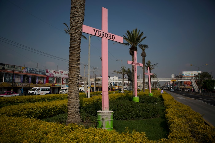 In this Aug. 15, 2007 photo, pink crosses covered with the Spanish words: "Truth," "Justice," and "Restitution" stand in a road median in downtown Nezahualcoyotl, Mexico state. In June, Valeria Teresa Gutierrez Ortiz, 11, disappeared in this town after taking a public bus home from school. She was later found dead in the abandoned vehicle, partially clothed and with signs of sexual assault. (AP Photo/Rebecca Blackwell)