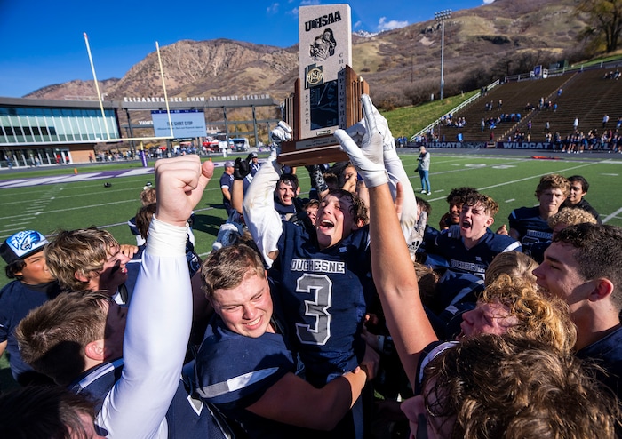 (Rick Egan | The Salt Lake Tribune) Kraden Skewes holds up the 1A Championship trophy, as the Duchesne Eagles celebrate their victory over the Layton Christian Academy  Eagles, at the Elizabeth Dee Shaw Stewart Stadium in Ogden, on Saturday, Nov. 13, 2021.